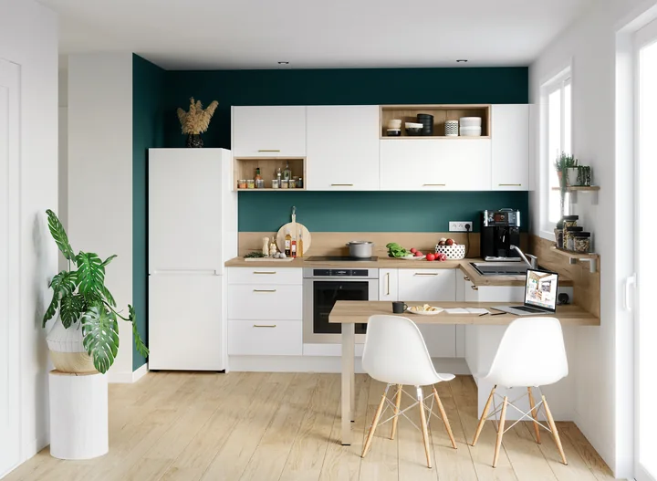 Cuisine Escale blanche avec coin repas et mur vert